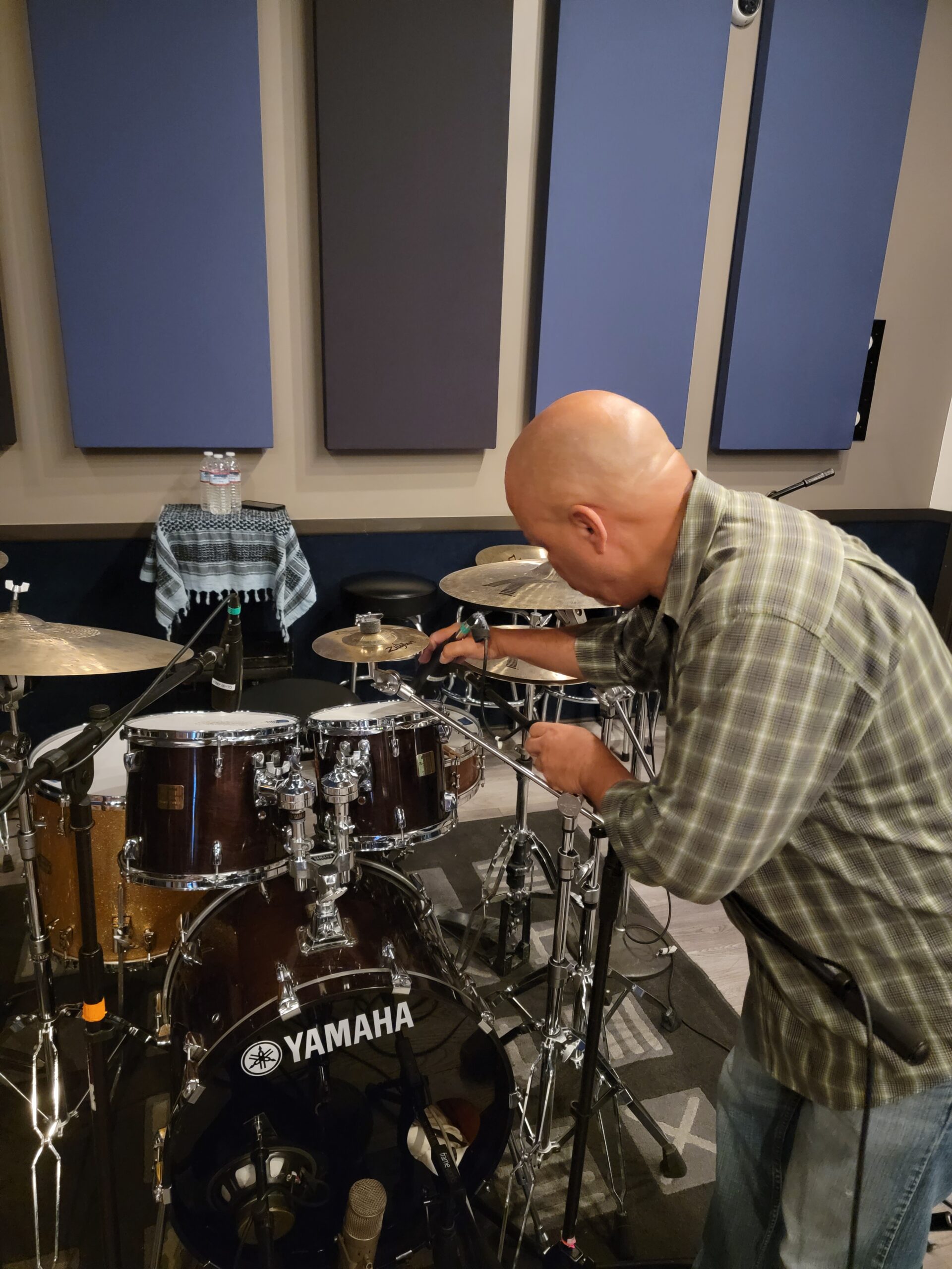Picture o Ralph Sutton Recording Engineer adjusting Drum Mic Setup for Recording Session.
