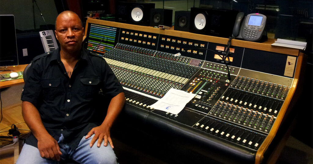 Picture of Ralph Sutton Recording Engineer sitting in front of a vintage API recording console during a recording session